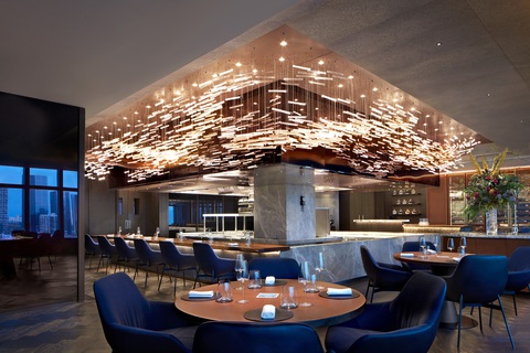 Nguyên liệu Việt hòa quyện trên bàn tiệc fine dining- Ảnh 4. Khu vực bếp mở lộng lẫy dưới dàn sóng đèn chùm như một dòng chảy của đại dương