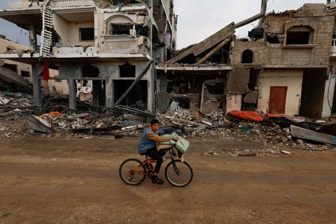 Một cậu bé Palestine đạp xe ngang qua những tòa nhà đổ nát ở Khan Younis, phía Nam Gaza, ngày 27-11 - Ảnh: REUTERS Một cậu bé Palestine đạp xe ngang qua những tòa nhà đổ nát ở Khan Younis, phía nam Gaza ngày 27-11 - Ảnh: REUTERS