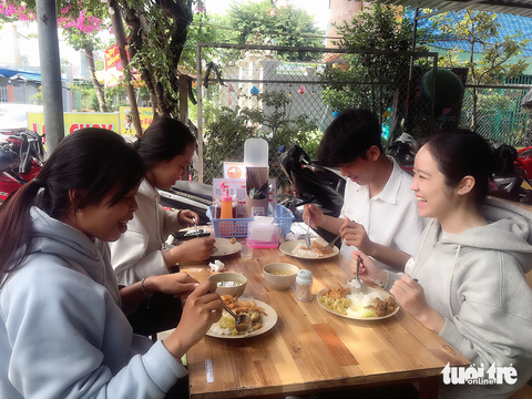 9X mở quán cơm chay, tặng suất ăn 0 đồng cho bà con- Ảnh 4. Nhóm bạn sinh viên vui vẻ ăn cơm 0 đồng - Ảnh: ĐẶNG TUYẾT