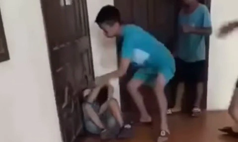Nam sinh lớp 7 bị đánh hội đồng đến quên cả tên đã đi học trở lại- Ảnh 1. Nhóm nam sinh vừa đánh hội đồng bạn vừa quay clip - Ảnh cắt từ clip