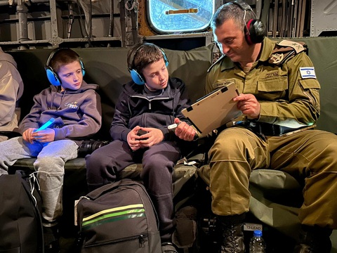 Toàn cảnh điều kiện ăn ở, giam giữ các con tin ở Hamas- Ảnh 4. Hai anh em người Israel Tal Goldstein-Almog (9 tuổi) và Gal Goldstein-Almog (11 tuổi) ngồi cạnh binh sĩ Israel sau khi được Hamas trả tự do. Ảnh chụp tại một địa điểm không xác định và được công bố hôm 27-11 - Ảnh: REUTERS/IDF