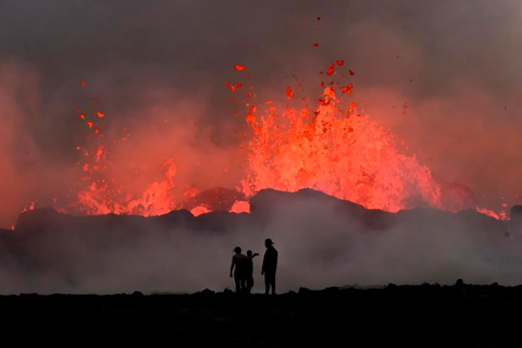 People watch flowing lava during an volcanic eruption near Litli Hrutur, south-west of Reykjavik in Iceland on July 10, 2023.AFP VIA GETTY IMAGES Người dân đứng nhìn dung nham chảy trong một vụ phun trào núi lửa gần Litli Hrutur, phía tây nam Reykjavik, Iceland vào ngày 10-7-2023 - Ảnh: AFP/GETTY IMAGES