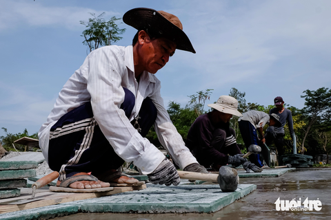 Sau hơn 20 năm, công viên lớn nhất Bình Tân hình thành từ bãi trung chuyển rác- Ảnh 2. Trưa 29-11, công nhân đang lát gạch nền đường, sẽ hoàn thiện và bàn giao cho chủ đầu tư công viên vào sáng mai - Ảnh: PHƯƠNG NHI