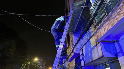 Xuyên đêm phá tường giải cứu nam thanh niên rơi vào kẹt trong khe hở giữa hai nhà dân- Ảnh 4. Lực lượng chức năng leo lên mái nhà xác định vị trí nam thanh niên mắc kẹt