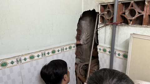 Xuyên đêm phá tường giải cứu nam thanh niên rơi vào kẹt trong khe hở giữa hai nhà dân- Ảnh 1. Cảnh sát phá tường giải cứu nam thanh niên mắc kẹt ra ngoài - Ảnh: PC07