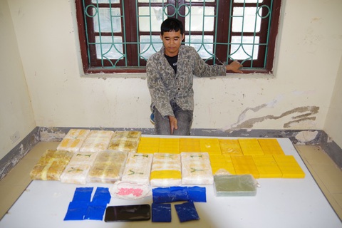 Bị bắt vì nhận vận chuyển 12 bánh heroin, hơn 50.000 viên ma túy- Ảnh 1. Lường Văn Vui với tang vật thu giữ được tại cơ quan điều tra - Ảnh: Bộ đội biên phòng tỉnh Điện Biên