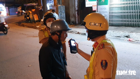Người vi phạm nồng độ cồn: 'Bắt 10 xe tôi cũng bỏ' - Ảnh 1. Anh C. thổi vào máy đo nồng độ cồn và có kết quả 0,995 mg/l khí thở - Ảnh: MINH HÒA
