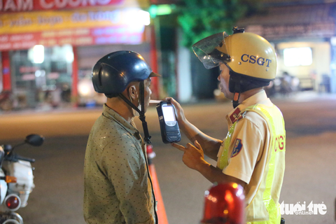 Người vi phạm nồng độ cồn: 'Bắt 10 xe tôi cũng bỏ' - Ảnh 2. Anh T.Q.A. thổi vào máy đo nồng độ cồn và có kết quả 0,741 mg/l khí thở - Ảnh: MINH HÒA
