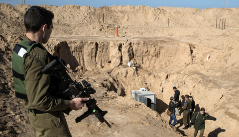 Kỹ sư Israel dùng robot và thuốc nổ, quyết ép Hamas ‘chết trong đường hầm’ - Ảnh 1. Binh sĩ Israel đứng bên ngoài khu vực được cho là đường hầm của Hamas nối Dải Gaza với Israel - Ảnh: REUTERS