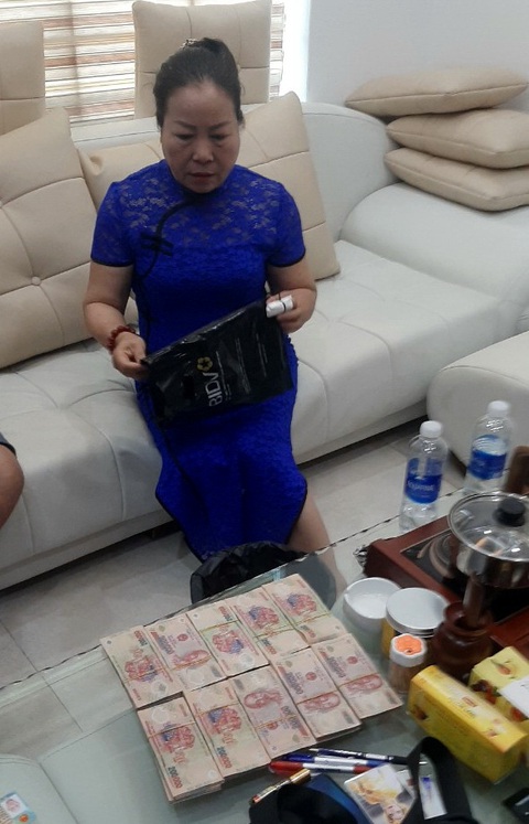 Bắt đôi vợ chồng lừa đảo ‘trục vong, trừ tà’ - Ảnh 3. Nguyễn Thị Lý lúc nhận tiền "trục vong, trừ tà" - Ảnh: Công an cung cấp