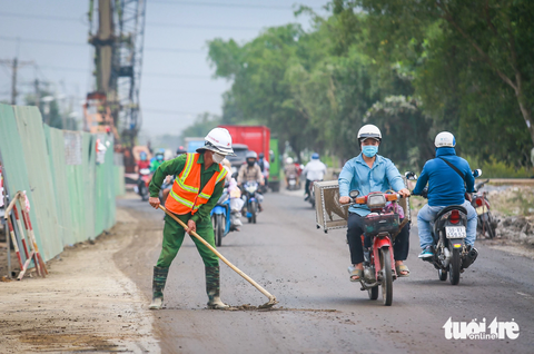 Cấp tập 3 ca 4 kíp trên đại công trình vành đai 3 TP.HCM- Ảnh 5. Khi xây dựng công trình cần sự phục vụ của nhiều máy móc, xe cơ giới chở vật liệu, nên việc đất cát vương vãi khó tránh khỏi. Do đó, đơn vị giám sát thi công phải thường xuyên nhắc nhở anh em dọn dẹp, đảm bảo an toàn giao thông cho người đi đường - Ảnh: THU DUNG