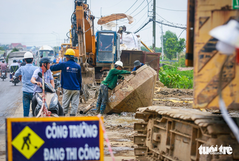 Cấp tập 3 ca 4 kíp trên đại công trình vành đai 3 TP.HCM- Ảnh 7. Trước khó khăn nêu trên, Ban Giao thông kiến nghị UBND TP.HCM làm việc với UBND các tỉnh có nguồn vật liệu cát san lấp hỗ trợ cung cấp cho dự án đường vành đai 3. Trong ảnh là các công nhân đang vệ sinh phễu để đổ bê tông, cát - Ảnh: CHÂU TUẤN