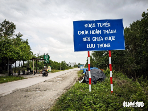 Đường trăm tỉ 7 năm chưa khớp nối quốc lộ 1A vì vướng 1 hộ dân- Ảnh 1. Cơ quan chức năng cắm bảng thông báo chưa lưu thông tuyến đường nối ven biển Quảng Nam với quốc lộ 1A vì chưa hoàn thành khớp nối - Ảnh: TẤN LỰC
