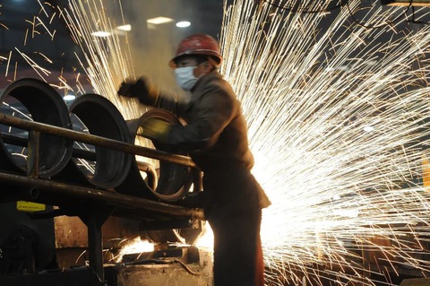 A Chinese worker goes about his chores at a steel mill in Hefei, in eastern China's Anhui province on December 23, 2010. AFP Công nhân làm việc tại một nhà máy thép ở Hợp Phì, tỉnh An Huy, miền đông Trung Quốc - Ảnh: AFP
