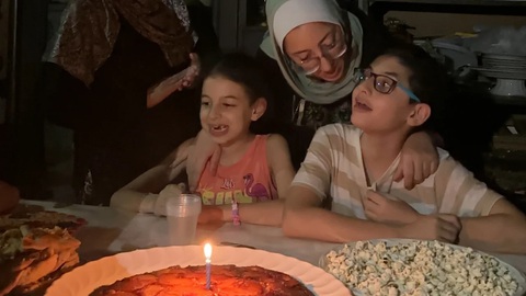 Điều ước hòa bình trong sinh nhật 12 tuổi của cậu bé Palestine ở Gaza - Ảnh 1. Cậu bé Hashem (bìa phải) đón sinh nhật 12 tuổi bên chiếc bánh dứa yêu thích, cùng với em gái Basma và mẹ Hiba - Ảnh: CNN