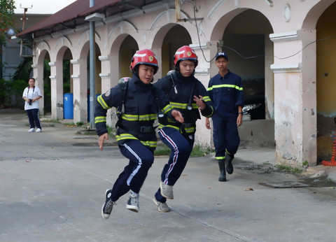 'Một ngày làm lính cứu hỏa' giúp học sinh kỹ năng thoát khỏi đám cháy - Ảnh 2. Học sinh vào vai lính cứu hỏa, khẩn cấp lao vào khu vực giả định có sự cố cháy nổ xảy ra - Ảnh: K.ANH