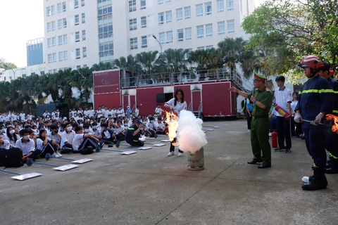 'Một ngày làm lính cứu hỏa' giúp học sinh kỹ năng thoát khỏi đám cháy - Ảnh 1. Học sinh thực hành chữa cháy - Ảnh: K.ANH