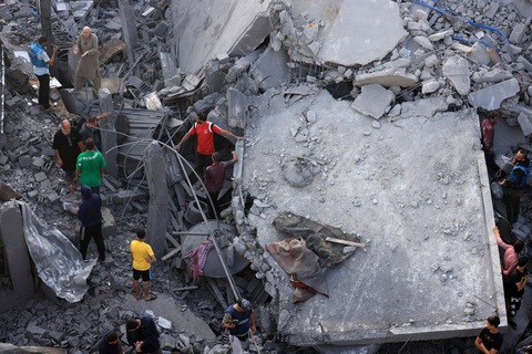 Dải Gaza: 21 người trong một gia đình thiệt mạng trong trận pháo kích tối 4-11 - Ảnh 1. Người dân tìm kiếm các nạn nhân còn mắc kẹt dưới những đống đổ nát ở trại tị nạn Maghazi - Ảnh: AFP