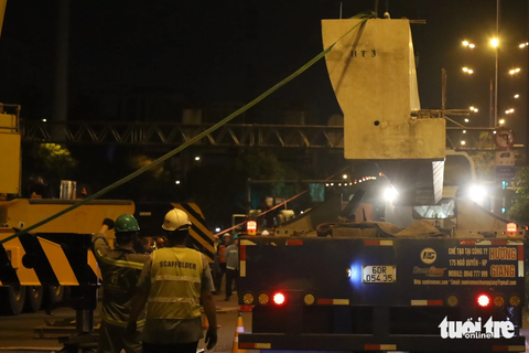 Thi công lắp đặt cầu bộ hành đầu tiên của tuyến metro số 1 - Ảnh 4. Dầm cầu bộ hành nặng hàng chục tấn được xe cẩu nhấc lên cao