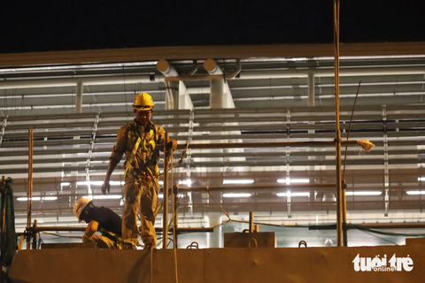 Thi công lắp đặt cầu bộ hành đầu tiên của tuyến metro số 1 - Ảnh 6. Công nhân thi công, kiểm tra các khớp nối hai bên cầu