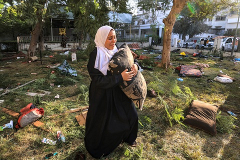 Nhìn lại một tháng xung đột Israel - Hamas - Ảnh 6. Ngày 18-10, một người phụ nữ đứng ở đống đổ nát bên ngoài bệnh viện Ahli Arab ở thành phố Gaza. Vào tối 17-10, bệnh viện này đã hứng chịu vụ tấn công được cho là khiến 500 người chết, gây ra làn sóng phẫn nộ và lên án từ khắp nơi trên thế giới - Ảnh: AFP