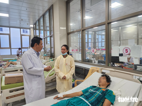 Cứu sống bé trai 14 tuổi sốc sốt xuất huyết, xuất huyết phổi nặng - Ảnh 1. Bác sĩ Đức khám và hỏi thăm sức khỏe bệnh nhân H. - Ảnh: HOÀI THƯƠNG