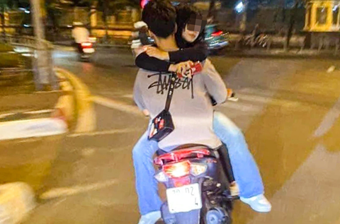 Nam sinh lái xe máy chở bạn gái đi chơi hồ Tây trong tư thế 'úp ngược' - Ảnh 1. Hình ảnh N.G.B. chở bạn gái trong tư thế quay ngược người - Ảnh: Công an cung cấp