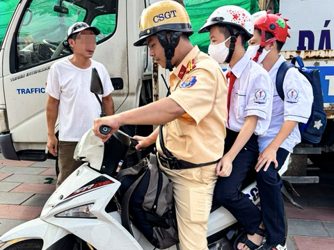 CSGT đưa 2 học sinh đến trường vì tài xế vi phạm nồng độ cồn bị giữ xe - Ảnh 1. Cảnh sát giao thông đưa 2 nam sinh đến trường sau khi lập biên bản xử lý vi phạm nồng độ cồn - Ảnh: H.Q.