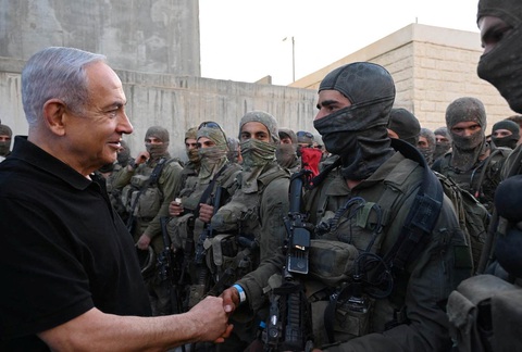 Tổng thống Israel Benjamin Netanyahu bắt tay các binh lính tại căn cứ ở Tze'elim ngày 7-11 - Ảnh: REUTERS Tổng thống Israel Benjamin Netanyahu bắt tay các binh lính tại căn cứ ở Tze'elim ngày 7-11 - Ảnh: REUTERS
