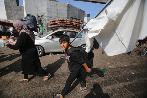 Một cậu bé Palestine cầm cờ trắng theo mẹ chạy khỏi thành phố Gaza - Ảnh: AFP Một cậu bé Palestine cầm cờ trắng theo mẹ chạy khỏi thành phố Gaza - Ảnh: AFP