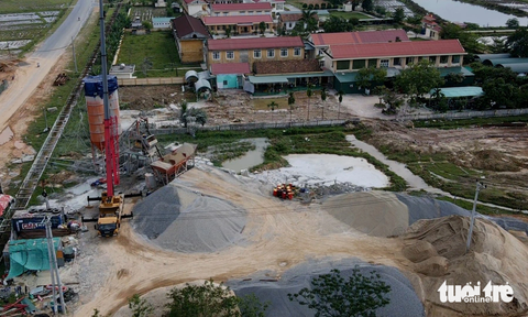 Trạm trộn bê tông xả khói bụi phủ kín trường học, nhưng không thể phạt vì không đo được chỉ số - Ảnh 2. Trạm trộn bê tông phục vụ thi công cao tốc Bắc - Nam được đặt giữa khu dân cư và sát ngay ba trường học của xã Quảng Sơn - Ảnh: Q.NAM