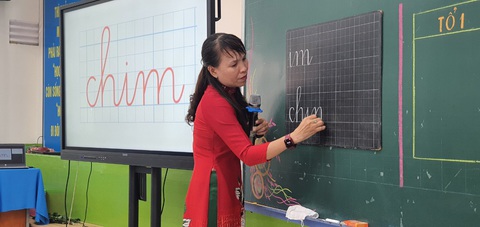 Phụ huynh dự giờ tiết học mở 'thấy thương cô giáo quá'- Ảnh 3. Cô Lý Thụy Thúy Lan dạy học sinh tập viết có sự hỗ trợ của bảng tương tác