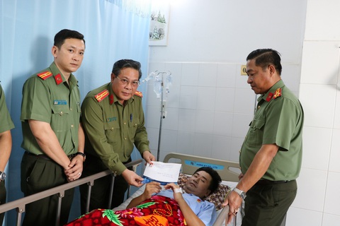 Công an bị đứt lìa hai chân khi bắt cát tặc: Hỗ trợ gần 200 triệu đồng- Ảnh 1. Công an tỉnh Kiên Giang đến thăm và trao phần quà với số tiền gần 200 triệu đồng cho đại úy Ngôi điều trị vết thương, sớm về với gia đình - Ảnh: QUỐC TRƯƠNG
