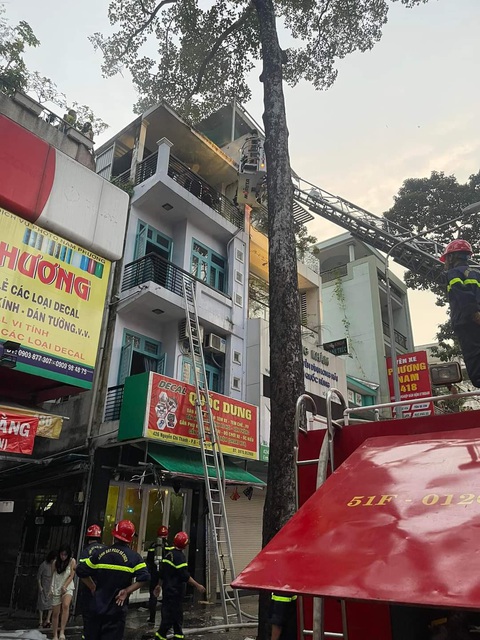 Cháy nhà, 6 người chạy ra ban công được cứu thoát- Ảnh 1. Cảnh sát đưa xe thang lên cứu 6 người mắc kẹt - Ảnh: PC07