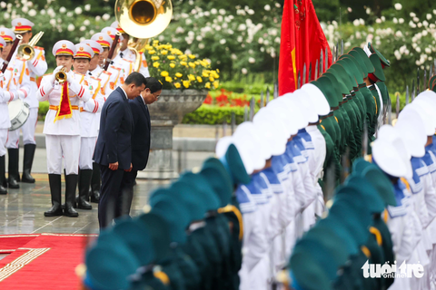 Thủ tướng Hun Manet tái ngộ Thủ tướng Phạm Minh Chính tại Hà Nội- Ảnh 3. Hai Thủ tướng cúi đầu chào quân kỳ Quân đội nhân dân Việt Nam trước khi duyệt đội danh dự - Ảnh: NGUYỄN KHÁNH