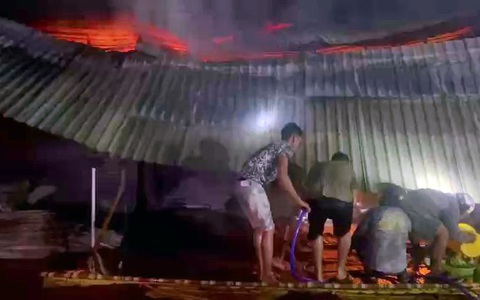 Chợ Thống Nhất bùng cháy trong đêm, nhiều ki ốt bị thiêu rụi- Ảnh 1. Người dân dùng các vật dụng tại chỗ dập đám cháy tại chợ Thống Nhất - Ảnh: AN BÌNH