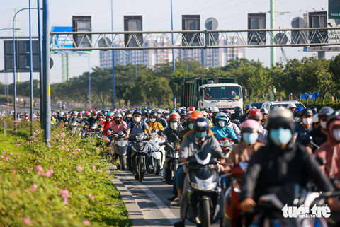 Tình trạng xe dồn nén có xảy ra ở đoạn &quot;nút thắt cổ chai&quot; tại cột đèn giao thông xanh đỏ (phân luồng đường cho xe lớn chạy về hướng trung tâm TP và lên cầu vượt về cảng Cát Lái) cách dốc cầu Rạch Chiếc 100m, nhưng đa số người dân vẫn chấp hành nghiêm túc - Ảnh: CHÂU TUẤN