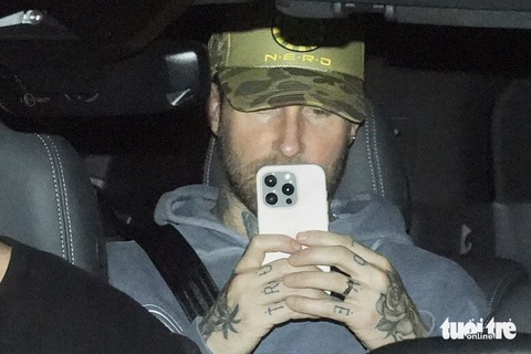 Đến Phú Quốc lúc nửa đêm, Maroon 5 dùng điện thoại quay cảnh phóng viên săn hình- Ảnh 1. Adam Levine cầm điện thoại quay nhóm phóng viên săn ảnh trên xe ra khỏi sân bay - Ảnh: HỮU HẠNH