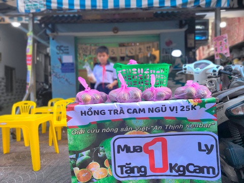 Quên trà chanh giã tay đi, cam sành đang kêu cứu- Ảnh 1. Quán Fuji Milk Tea nằm trên đường Bạch Vân (quận 5) treo biển mua 1 ly nước tặng 1kg cam nhằm giúp bà con tránh cảnh đổ bỏ nông sản - Ảnh: NHẬT XUÂN