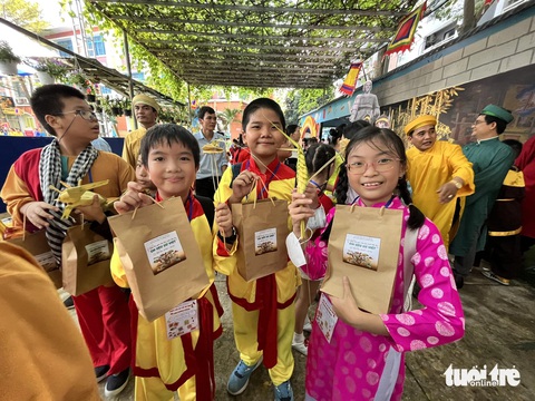 Học sinh tiểu học TP.HCM vui hết cỡ trong giao lưu Em Nguyễn Trần Kim Ngân và các bạn hào hứng khoe quà được nhận sau khi tham gia nhiều trò chơi - Ảnh: MỸ DUNG
