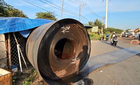 Đứt xích chằng, 3 cuộn sắt nặng hàng tấn văng khỏi rơ moóc- Ảnh 1. Một cuộn sắt văng khỏi rơ moóc, lăn trên đường hàng chục mét - Ảnh: B.H.