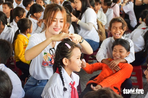 Các em nữ học sinh được các tình nguyện viên chỉnh trang tóc tai, trang phục trước khi vào chụp ảnh - Ảnh: TRẦN HOÀI Các em nữ học sinh được các tình nguyện viên chỉnh trang tóc tai, trang phục trước khi vào chụp ảnh - Ảnh: TRẦN HOÀI