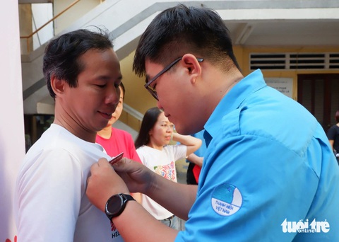 Ảnh chân dung tươi như hoa của bệnh nhi, cụ già neo đơn- Ảnh 2. Phó chủ tịch Hội Liên hiệp thanh niên Việt Nam TP.HCM Phạm Lê Minh Khang đeo huy hiệu