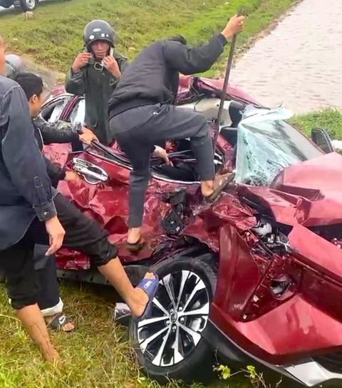 Tai nạn nghiêm trọng trên tuyến đường ven biển ở Hà Tĩnh- Ảnh 1. Người dân cạy cửa ô tô đưa người bị thương đi cấp cứu - Ảnh: H.A.