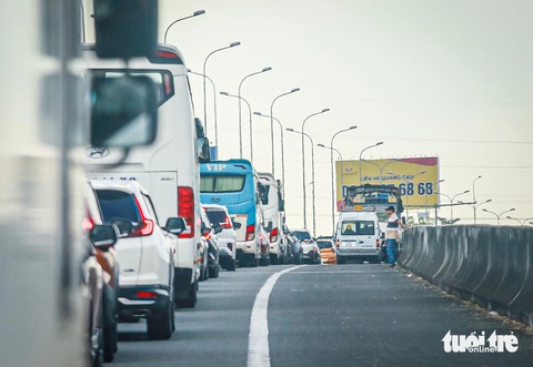 Kẹt cứng cao tốc TP.HCM - Long Thành - Dầu Giây, xe cộ tìm cách qua quốc lộ 51- Ảnh 5. Tài xế ô tô "sốt ruột" bỏ xe, đi bộ để xem tình hình giao thông - Ảnh: CHÂU TUẤN