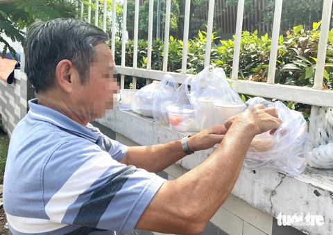 Bệnh nhân ung thư và suất ăn từ thiện: Đắn đo giá trị dinh dưỡng và tiết kiệm tiền chữa bệnh- Ảnh 3. Ông L. (60 tuổi, ngụ tỉnh Kon Tum) đang chăm mẹ bị ung thư cổ tử cung. Ngoài lấy phần ăn miễn phí cho mình, ông còn lấy thêm 2 phần bún xào, 2 phần bánh canh, 2 phần cháo cho mẹ bị bệnh và người em đang chăm bệnh - Ảnh: XUÂN MAI