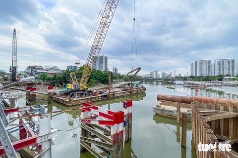 Tháo dỡ cầu sắt Rạch Đỉa nối quận 7, Nhà Bè để làm cầu mới- Ảnh 4. Một sà lan chở theo máy cẩu cỡ lớn đang tháo dỡ cầu sắt Rạch Đỉa cũ (ghi nhận chiều 18-12) - Ảnh: LÊ PHAN