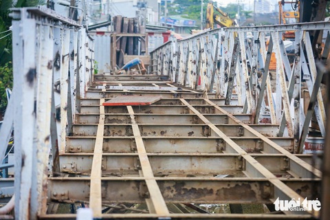 Tháo dỡ cầu sắt Rạch Đỉa nối quận 7, Nhà Bè để làm cầu mới- Ảnh 6. Gần 1/2 mặt cầu đã được tháo dỡ, để lộ ra sắt thép hoen gỉ, xuống cấp ở phía dưới - Ảnh: LÊ PHAN