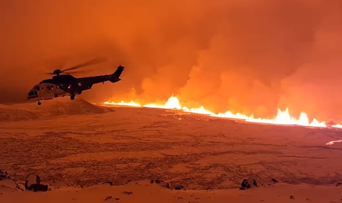 A handout photo from the Icelandic Coast Guard shows a coastguard helicopter flying over the volcano. Photograph: Icelandic Coast Guard/EPA Trực thăng của lực lượng bảo vệ bờ biển đang bay qua khu vực núi lửa - Ảnh: Lực lượng bảo vệ bờ biển Iceland/EPA