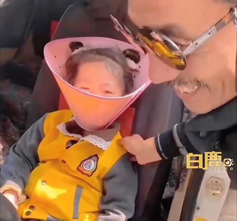 Ông nội đeo vòng cổ của chó cho cháu gái để cai nghiện điện thoại- Ảnh 1. Bé 5 tuổi được ông nội đeo vòng cổ hình chóp để không xem điện thoại - Ảnh: Weibo